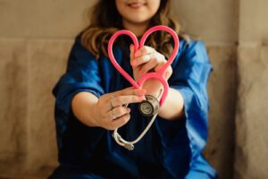 woman holding a stethoscope to show the empathy of a naturopath